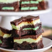 Two grasshopper brownies stacked on a white plate.