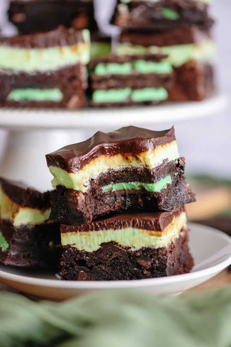 Two grasshopper brownies stacked on a white plate.