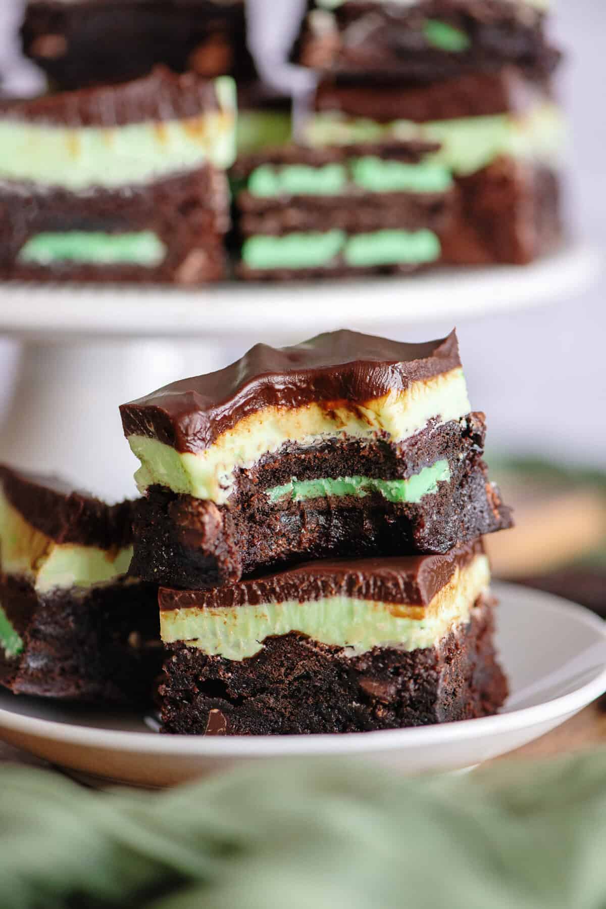 Two grasshopper brownies stacked on a white plate.