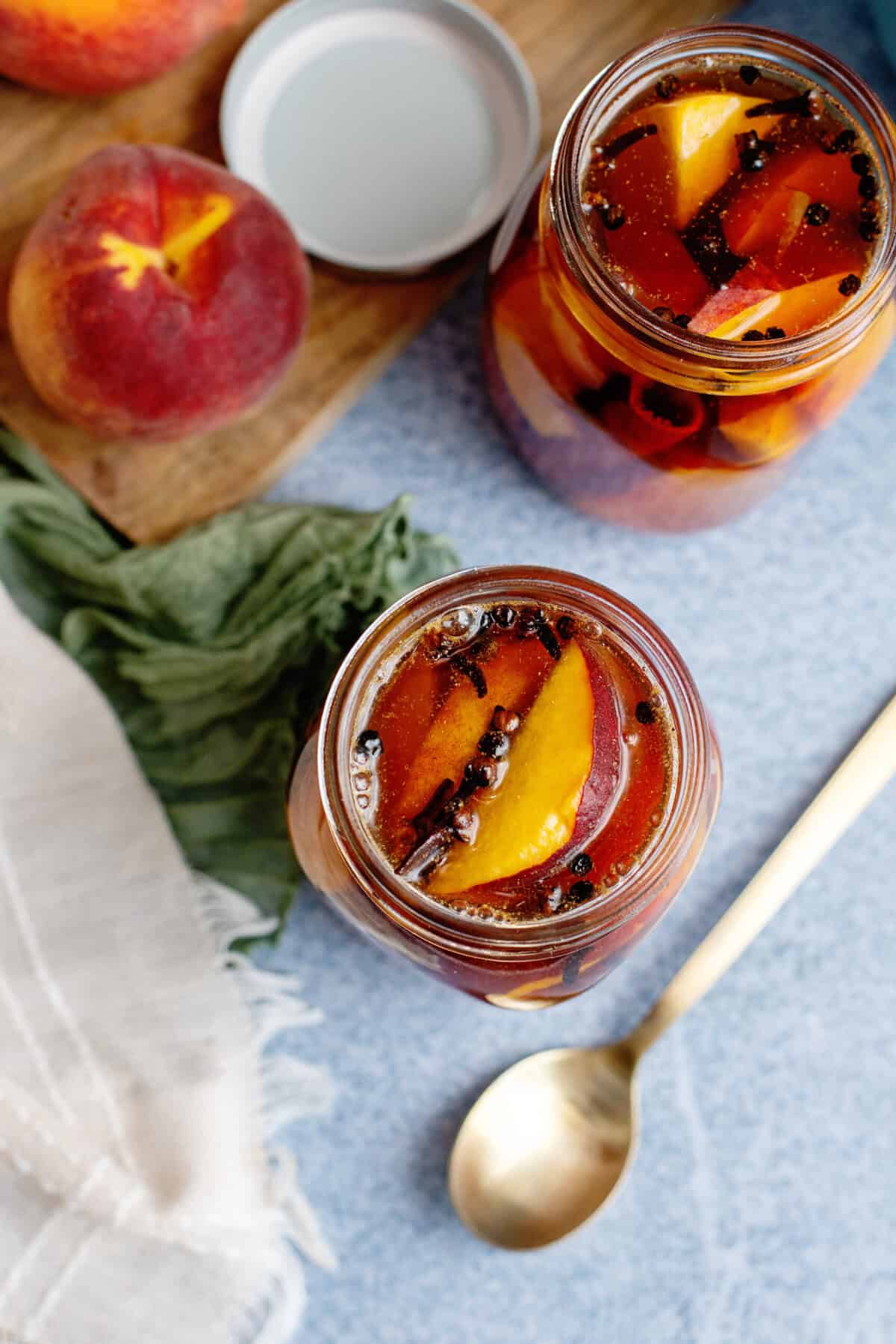 Overhead view of pickled peaches in a mason jar.
