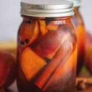 Pickled peaches in a mason jar.