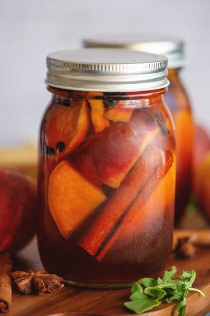Pickled peaches in a mason jar.