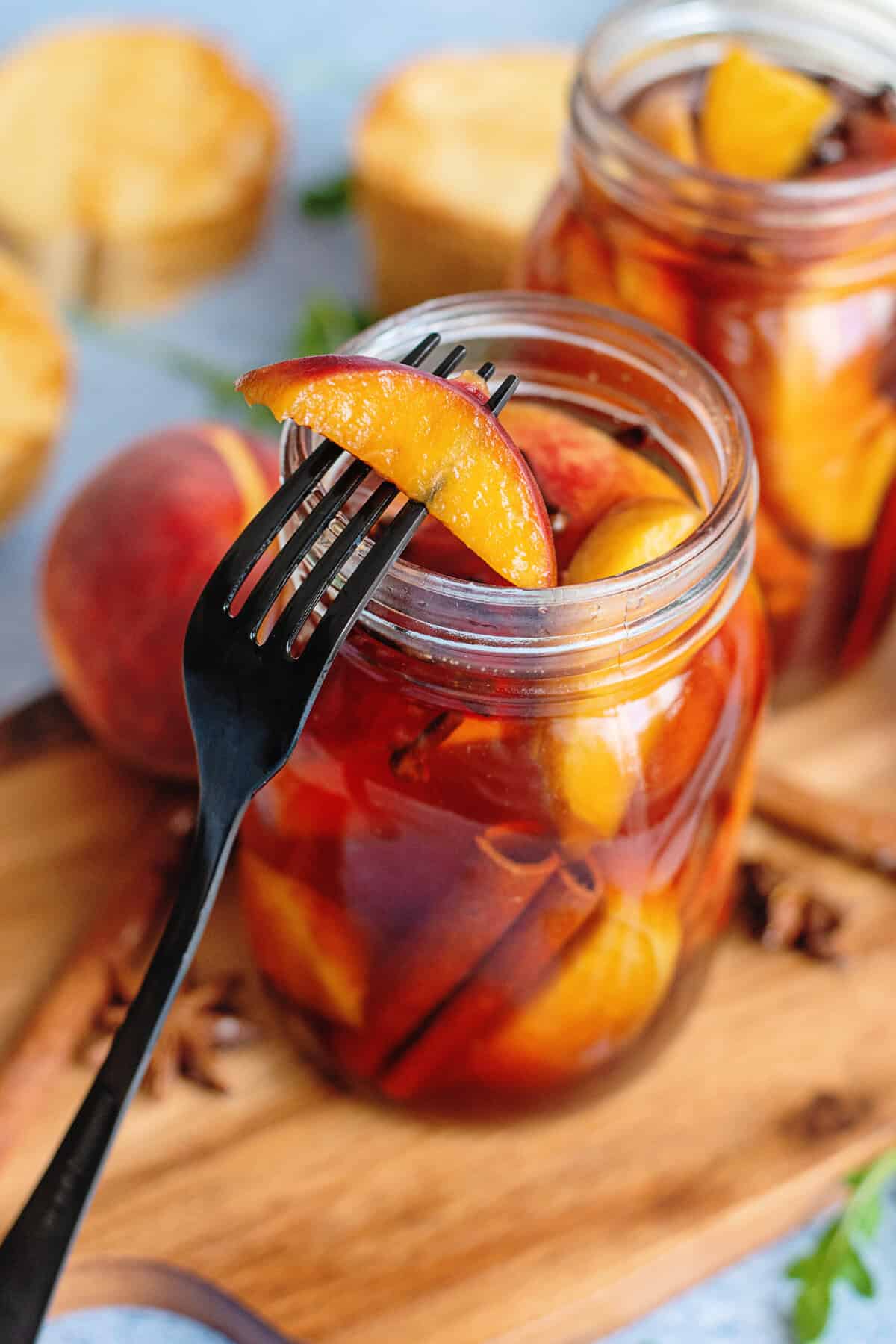 A pickled peach on a fork.