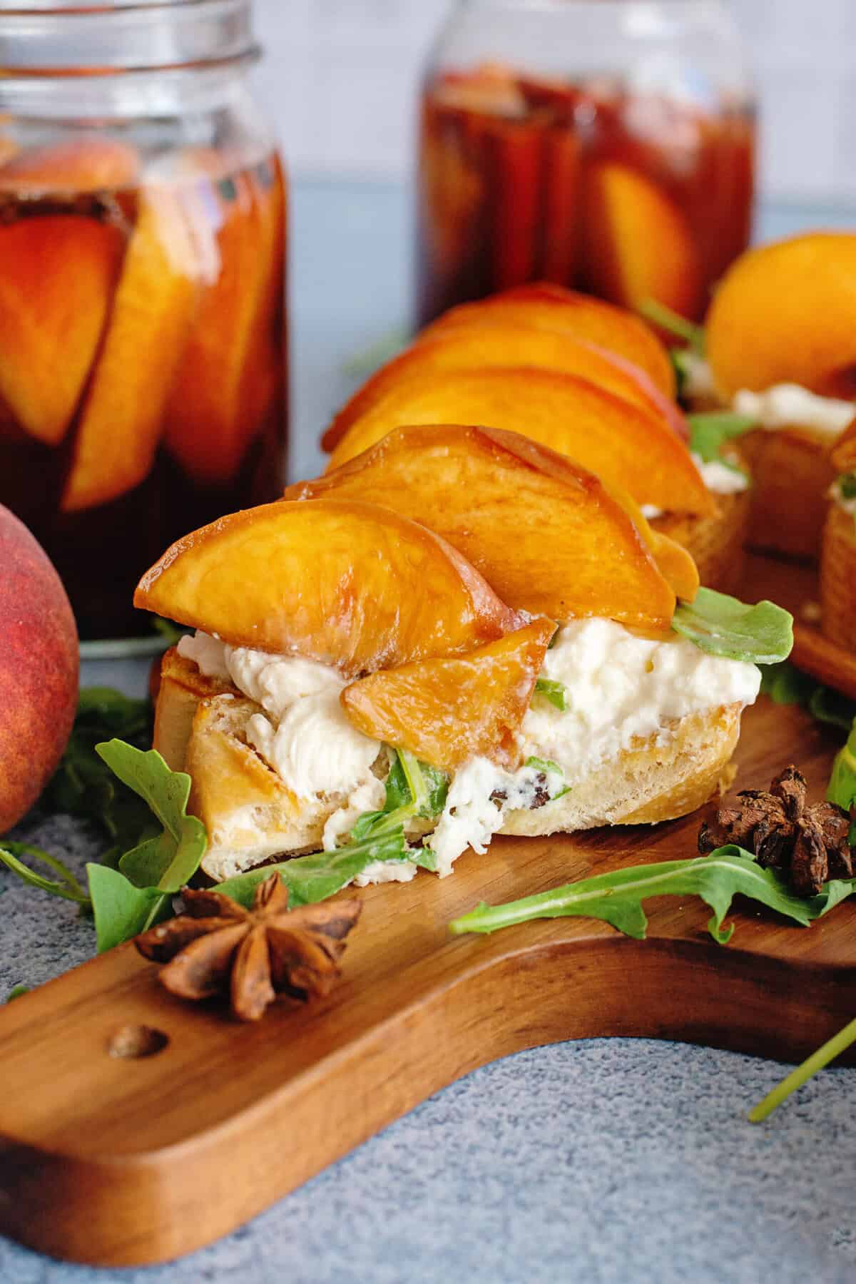 Pickled peaches on toast with arugula and burrata cheese.