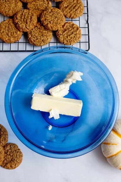 Butter and cream cheese in a glass blue mixing bowl.