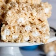 Rice Krispie treats stacked on each other on a cake stand.