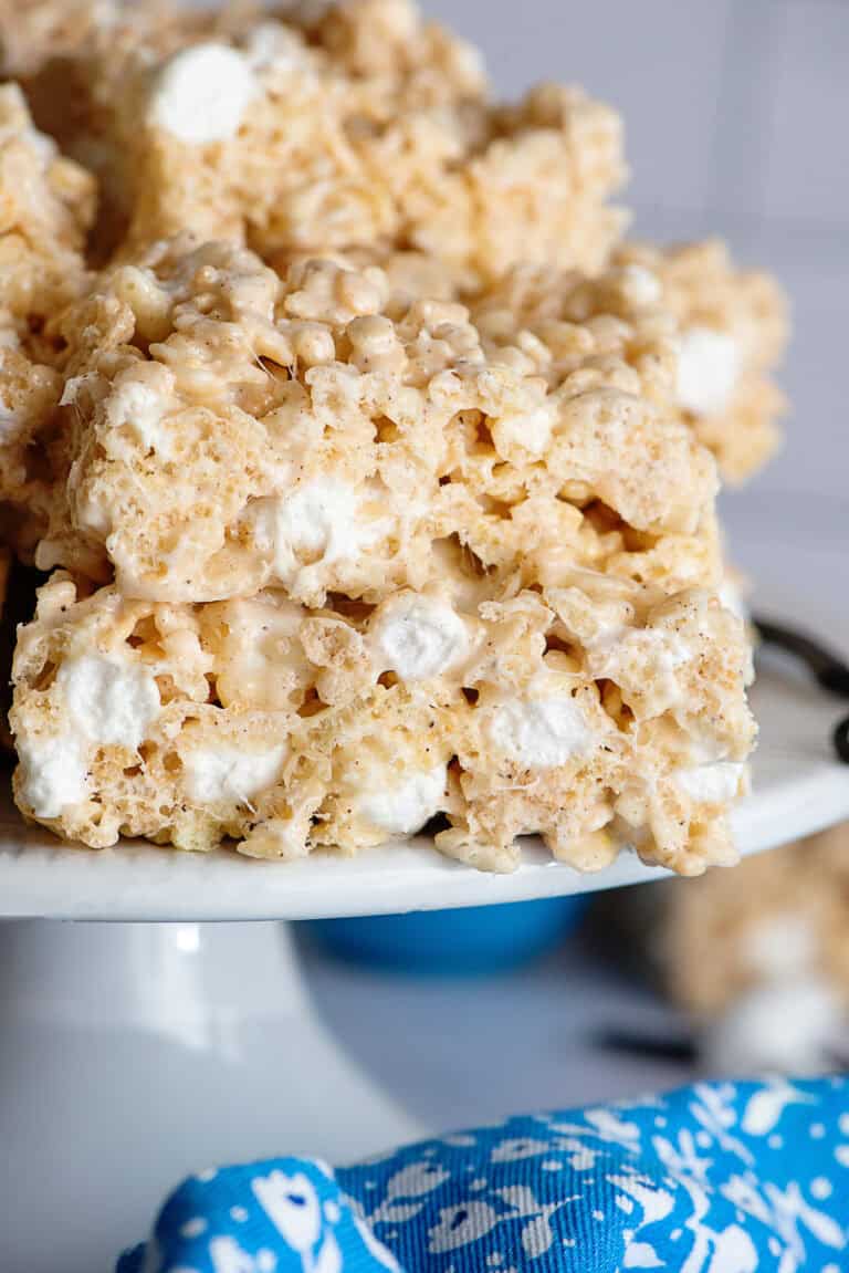 Rice Krispie treats stacked on each other on a cake stand.