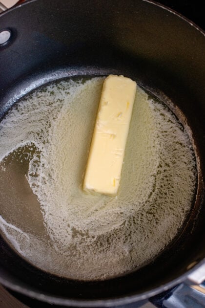 A stick of butter melting in a large pot.
