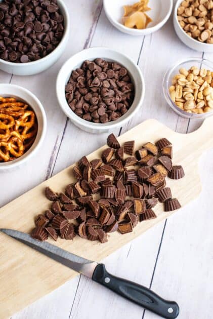 Chopping mini peanut butter cups on a cutting board