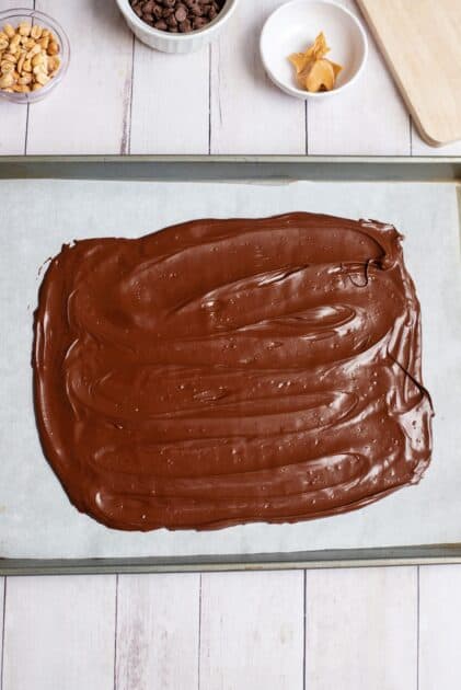 Melted chocolate spread on a parchment-lined baking sheet