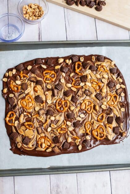 Pretzels, peanut butter cups, and peanuts pressed into swirled chocolate