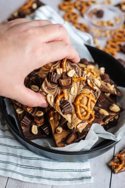 Hand grabbing a piece of chocolate pretzel bark