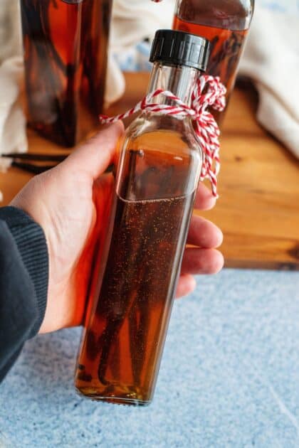 Hand holding a bottle of homemade vanilla extract