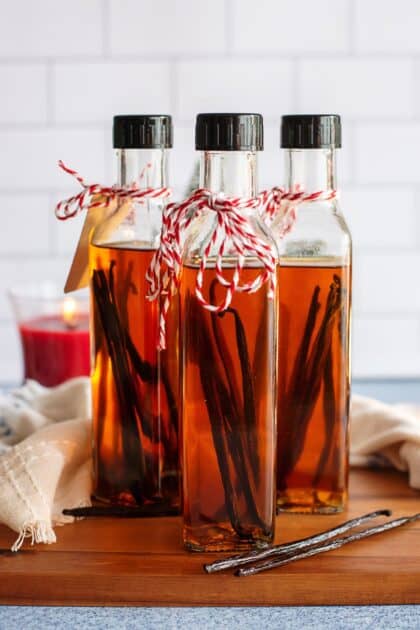 Three bottles of homemade vanilla extract with vanilla beans inside