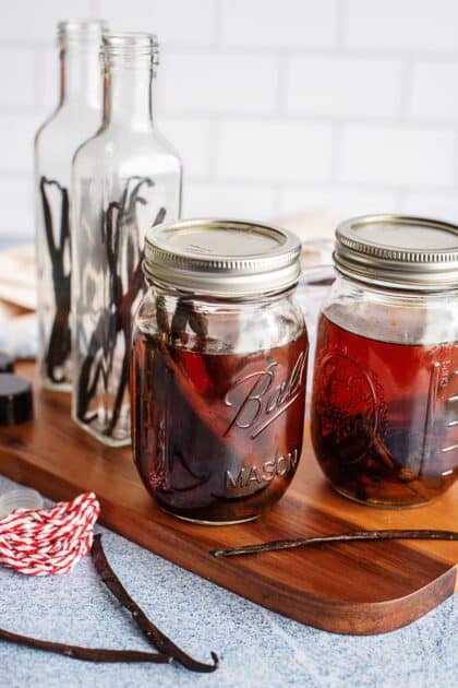 Fully infused amber vanilla extract in mason jars next to empty gift bottles