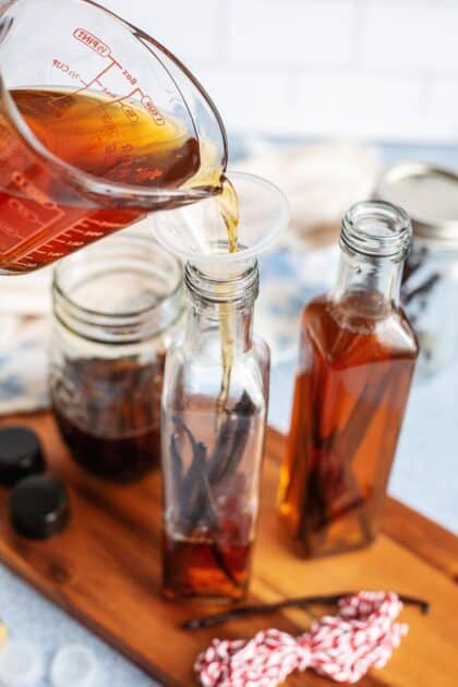 Pouring homemade vanilla extract into glass gift bottles